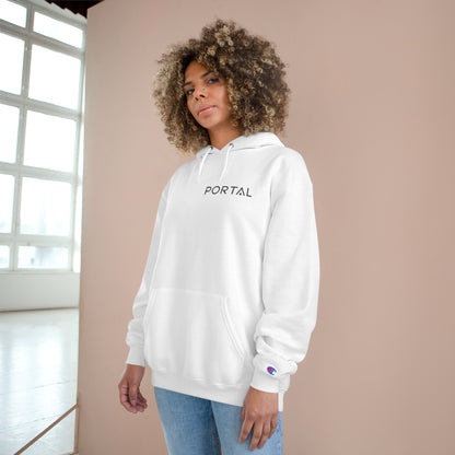 A woman modeling the white Champion S700 Eco Hoodie, featuring 'PORTAL' on the front and surrounded by a bright indoor setting.